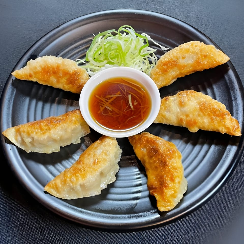 Six golden-brown Boru Ramen gyoza arranged around a small bowl of dipping sauce and shredded scallions.